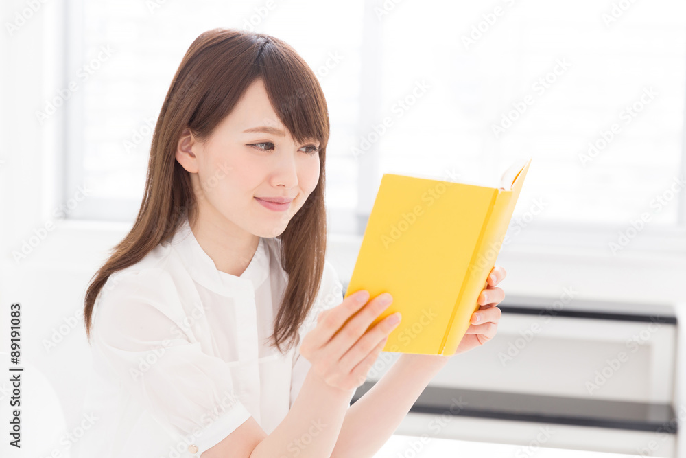 部屋で本を読む女性