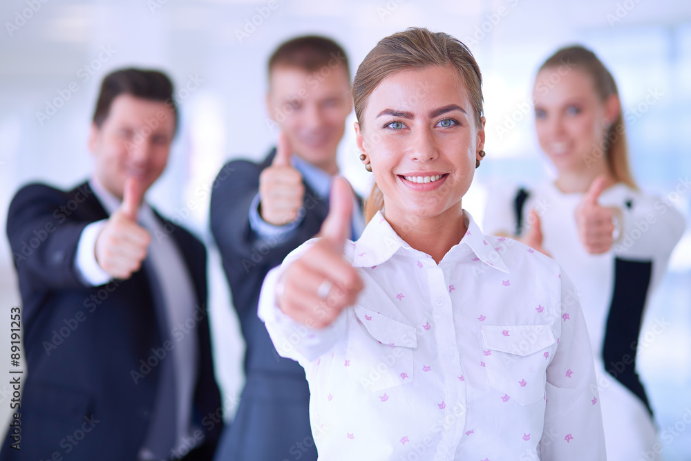 Happy business team showing thumbs up in office Happy business team showing thumbs up in office