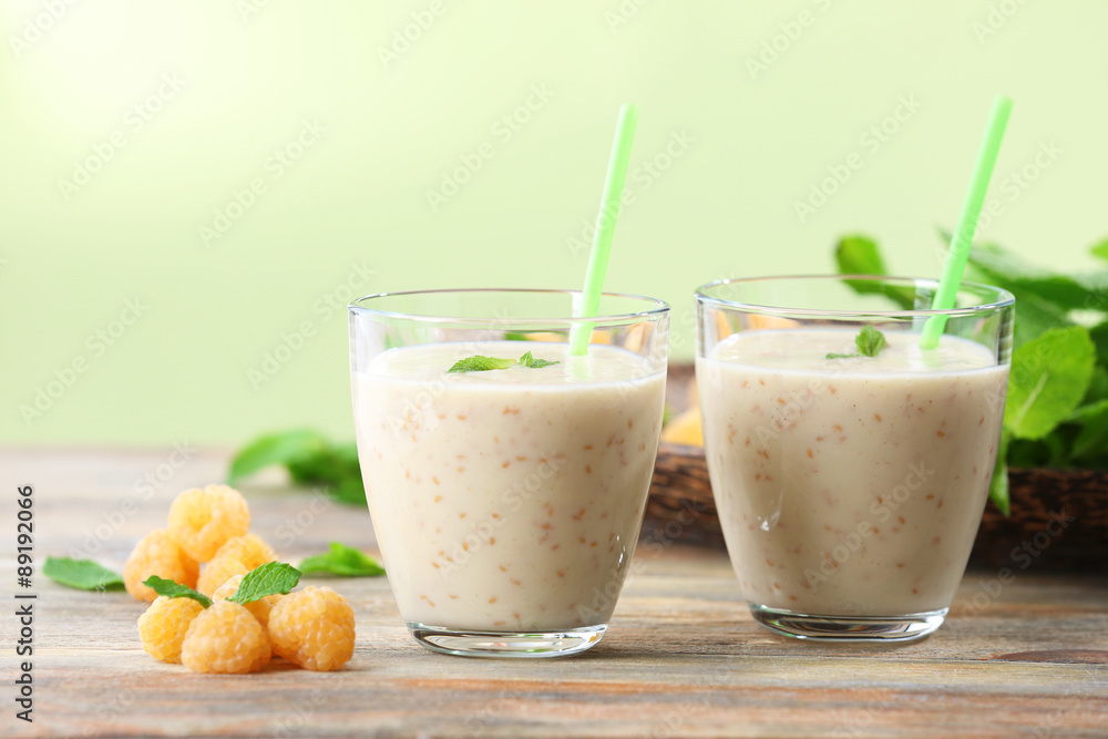Glasses of raspberry smoothie on wooden table on light background Glasses of raspberry smoothie on wooden table on light background
