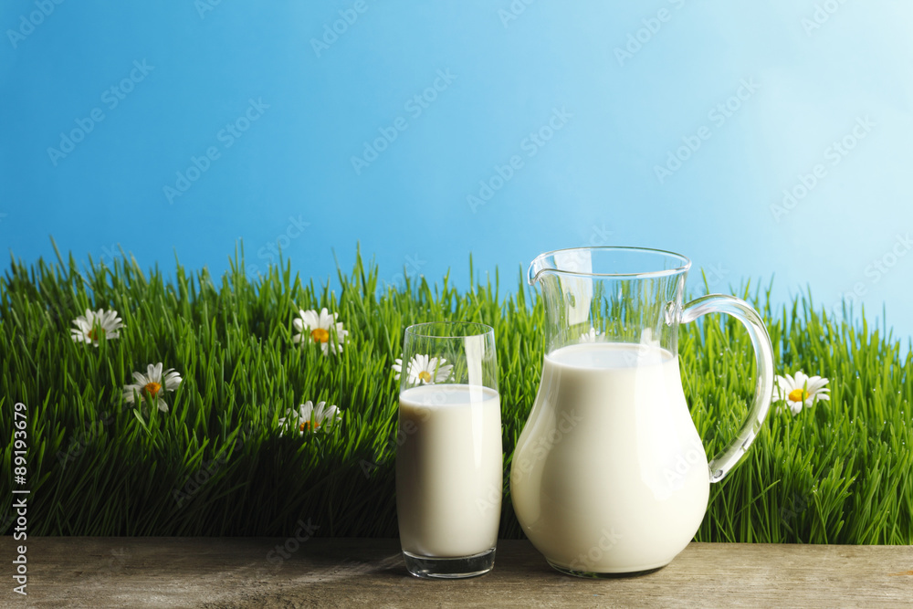 Glass of milk and jar on flower meadow Glass of milk and jar on flower meadow