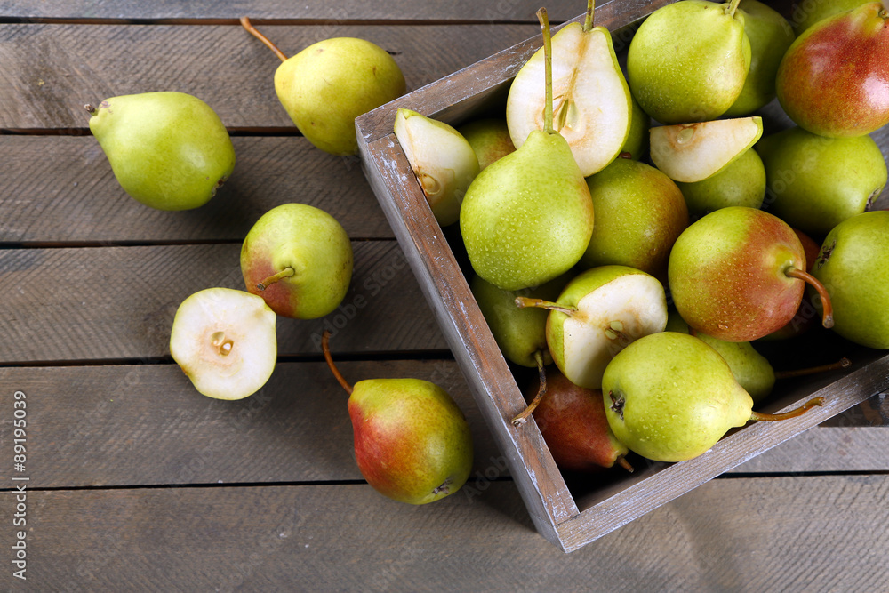 Ripe pears in wooden box on table close up Ripe pears in wooden box on table close up
