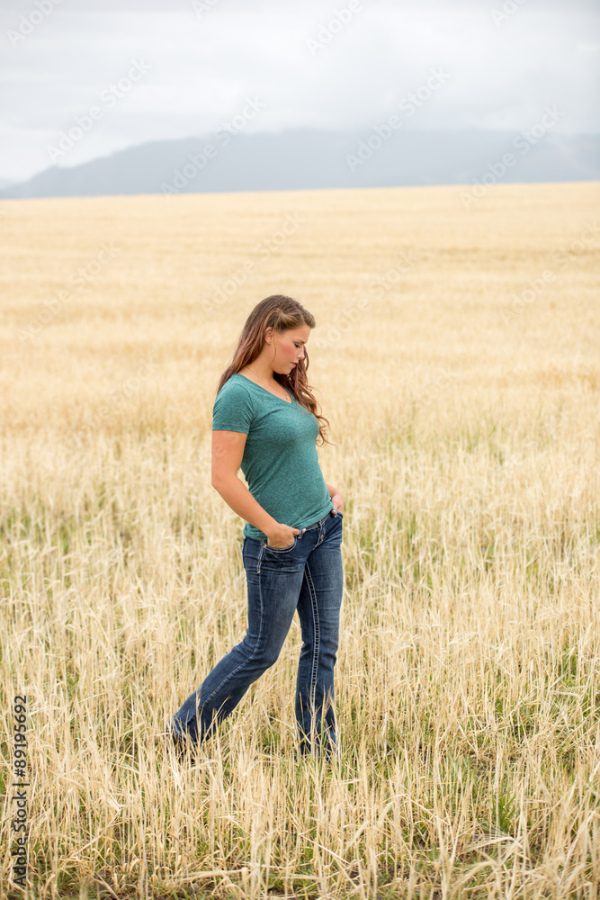 Young woman walking in wheat field.