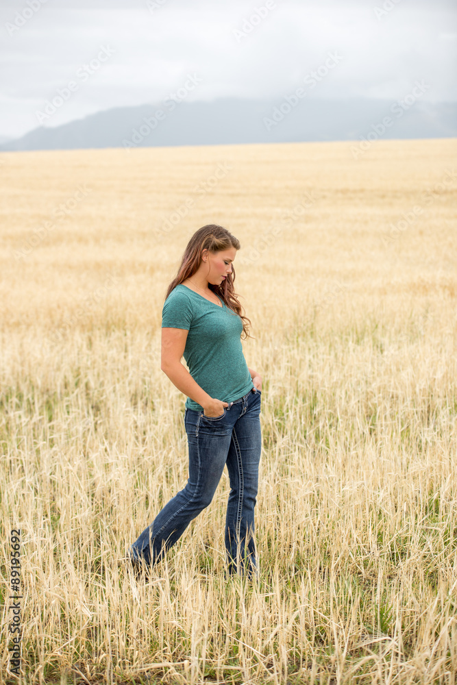 Young woman walking in wheat field. Young woman walking in wheat field.
