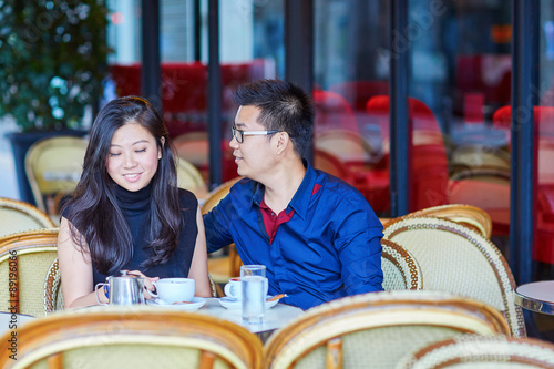 Young romantic Asian couple in Parisian cafe
