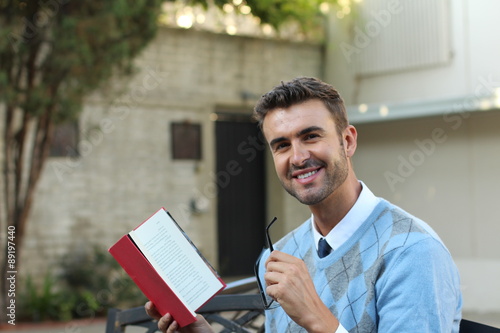 Young relaxed classic man reading book in park 