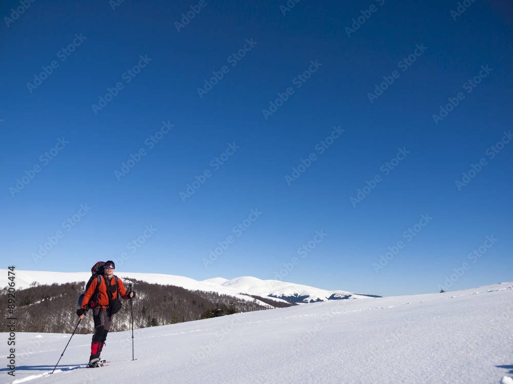 A man in snowshoes is the snow.