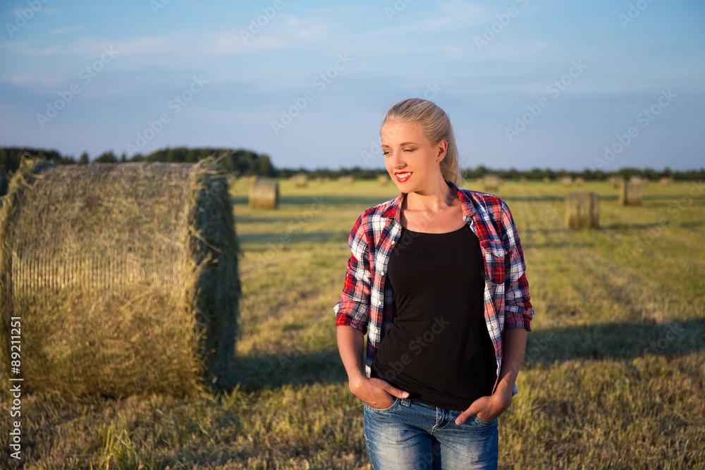 beautiful romantic country girl walking in field with haystacks