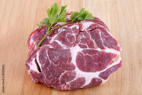 Fresh crude pork neck meat steak on wood background