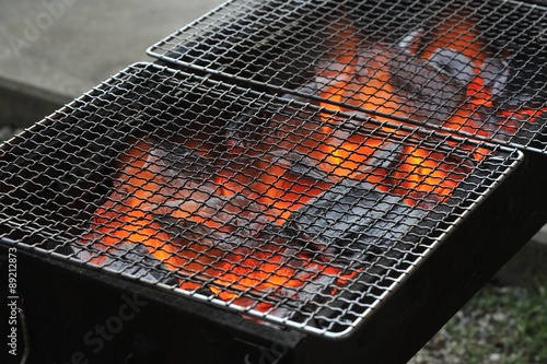 網を置いたバーベキュー（BBQ）コンロを上から写したの炭火の写真