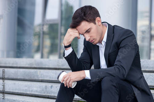 Attractive young businessman is worrying about his job