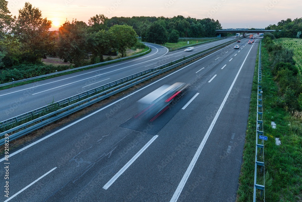 german highway at sunset with light trails from passing cars german highway at sunset with light trails from passing cars