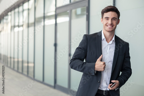 Handsome young man in suit is gesturing positively