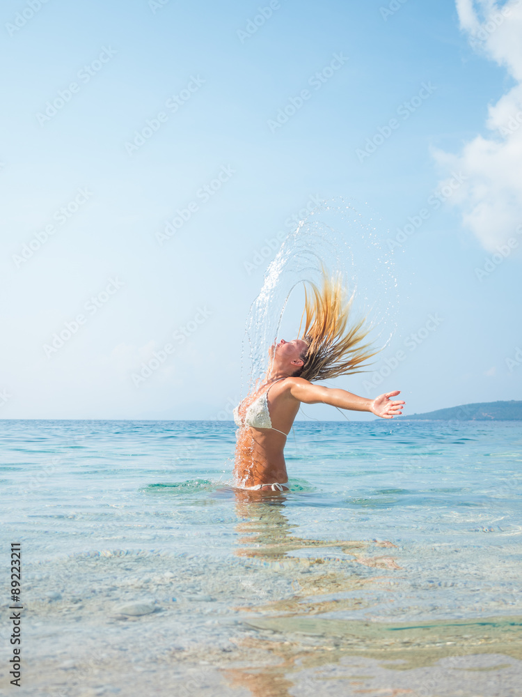 Naklejka premium blonde woman in the water waving hair