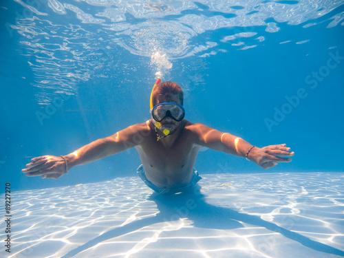 Full length of a young man wearing snorkel underwater