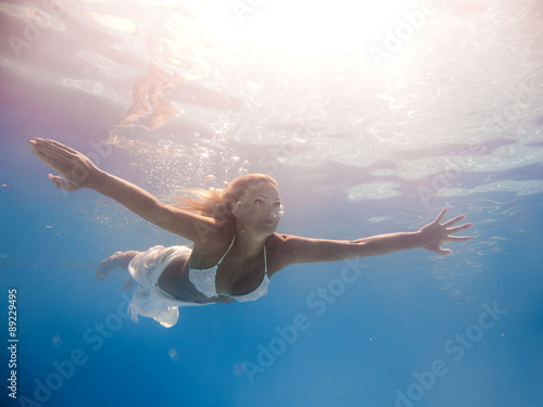 beautiful woman in white dress underwater