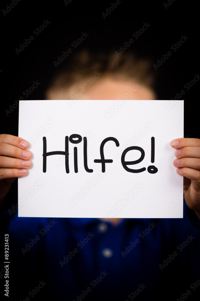 Child holding sign with German word Hilfe - Help Child holding sign with German word Hilfe - Help