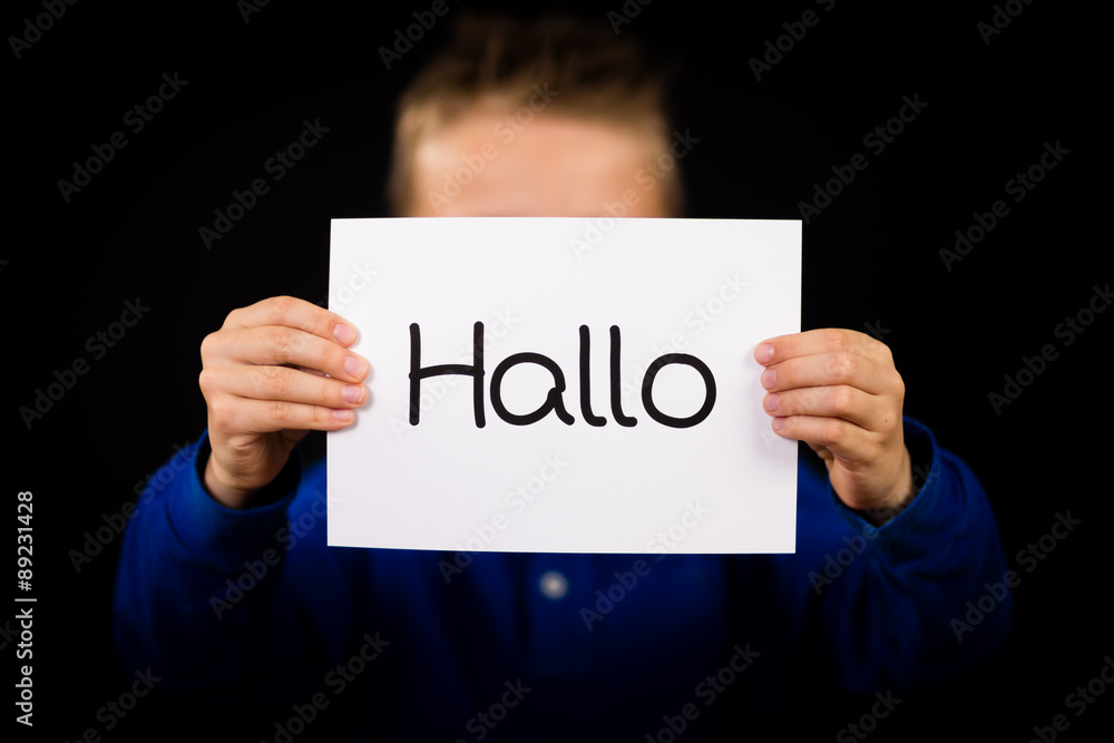 Child holding sign with German word Hallo - Hello in English Child holding sign with German word Hallo - Hello in English