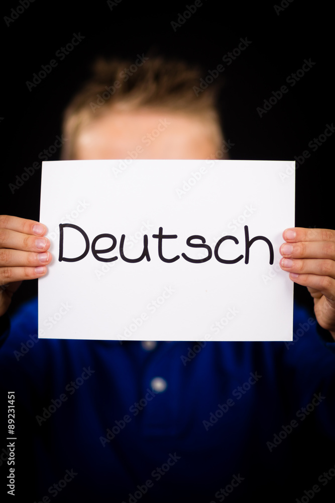 Child holding sign with German word Deutsch - German in English Child holding sign with German word Deutsch - German in English