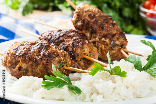Barbecued kofta with rice on a plate photo