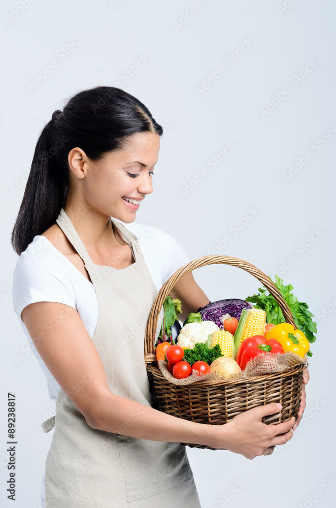 Attractive woman holding a basket of vegetables Attractive woman holding a basket of vegetables