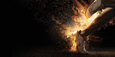 Sport. Runner. Side view of a jogger legs with the power in the veins isolated on black. Fire and energy
