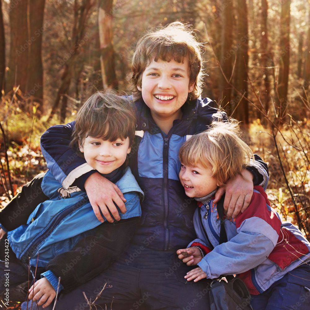 Naklejka premium three happy boys in autumn forest