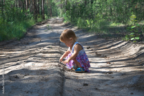 Baby girl on the road playing photo