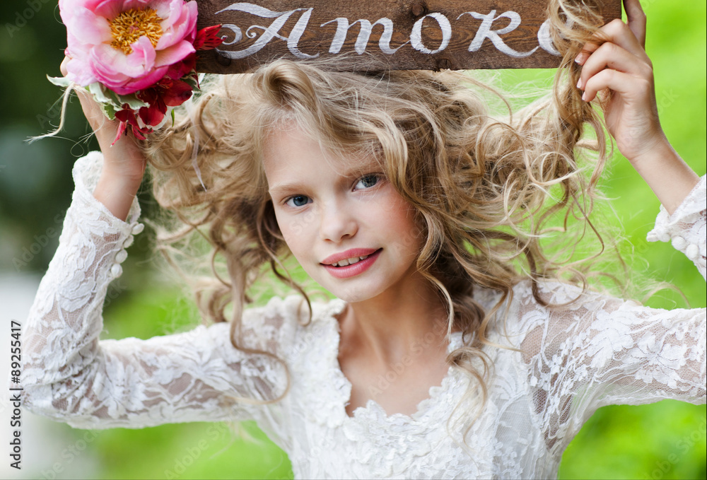 Happy cute little girl with long hair in long white dress sitting on ...