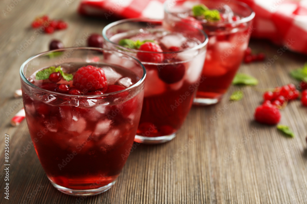 Glasses of berry juice on wooden table, closeup Glasses of berry juice on wooden table, closeup
