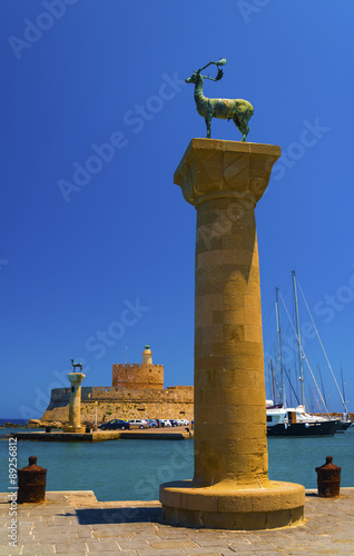 Statues stand either side of Mandraki harbour entrance