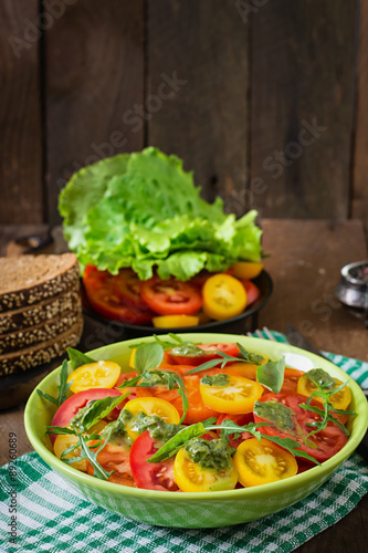 Summer tomato salad with basil, pesto and arugula