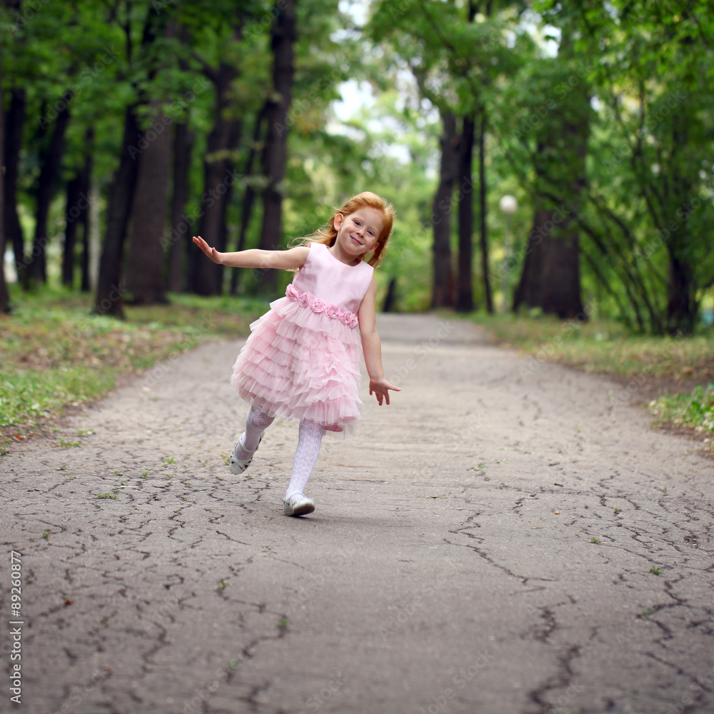 Happy little girl runs in a summer park Happy little girl runs in a summer park