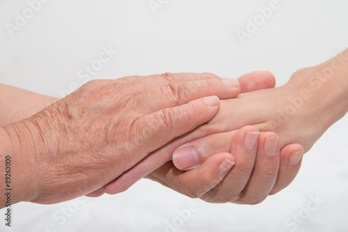 Elderly woman holding a young hand