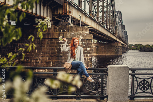 Redhead casual girl posing near big river.
