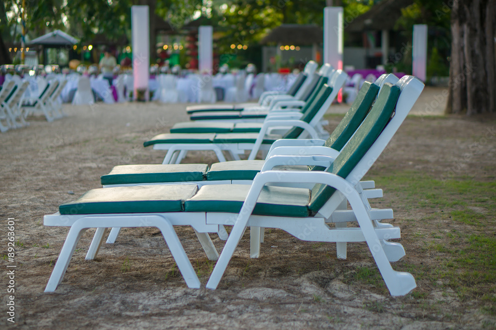 Rows of beach chairs among trees in the evening