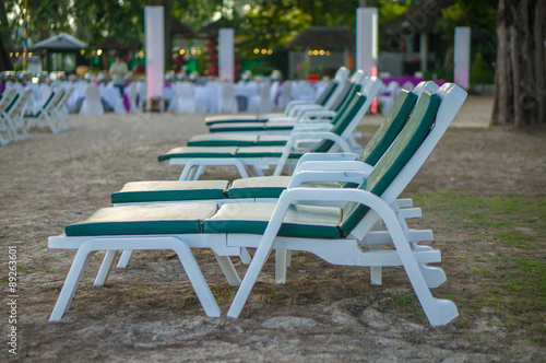 Rows of beach chairs among trees in the evening © Joshhh