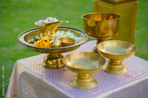 Asian buddhist wedding ceremony cups of gold with flowers