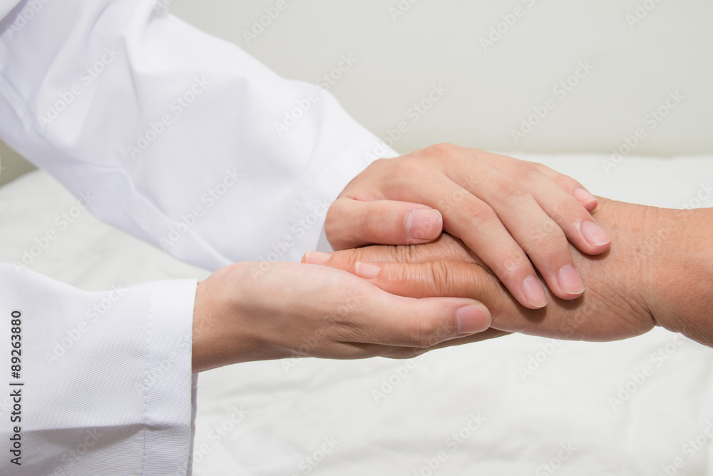 Doctor holding an old woman's hand Doctor holding an old woman's hand