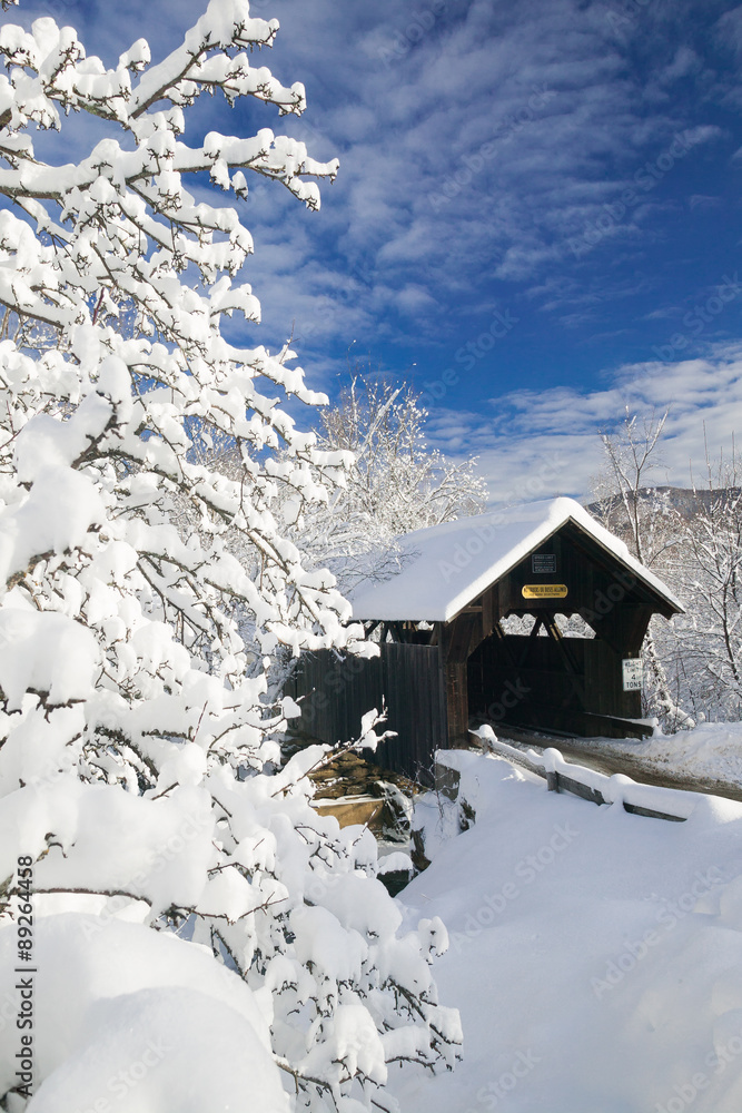 Covered bridged blanketed in fresh snow on a sunny winter mornin Covered bridged blanketed in fresh snow on a sunny winter mornin