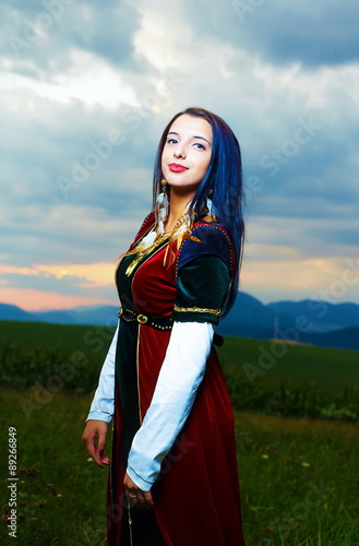 Young woman with medieval dress with sunset.