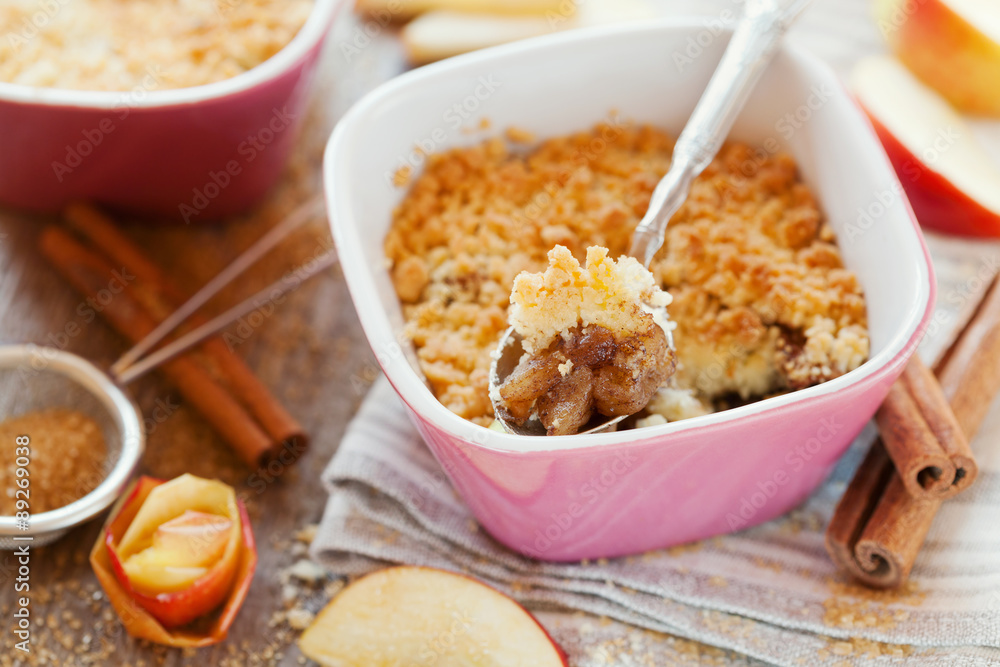 Apple crumble with cinnamon on rustic wooden table Apple crumble with cinnamon on rustic wooden table