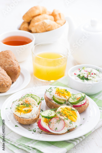 buns with boiled egg and vegetables for breakfast, vertical