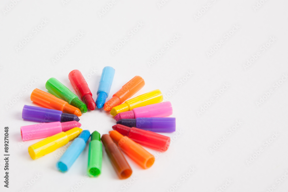 Multicolored crayons on a white paper background. Multicolored crayons on a white paper background.