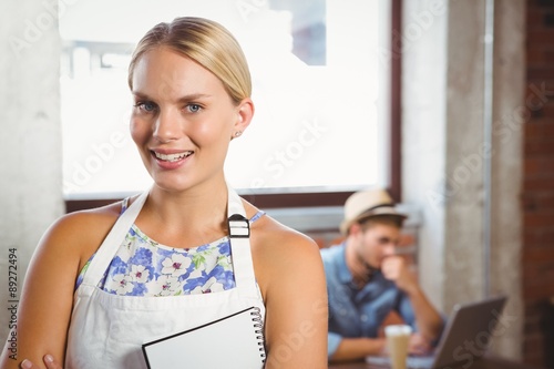 Smiling blonde waitress posing in front of customer Free Download Smiling blonde waitress posing in front of customer - GFXLoad