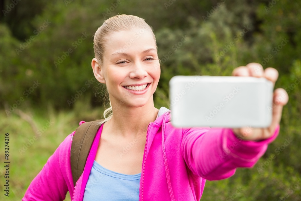 Smiling female hiker taking a selfie Smiling female hiker taking a selfie