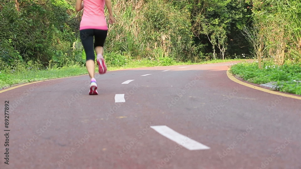 young fitness woman legs running at forest trail young fitness woman legs running at forest trail