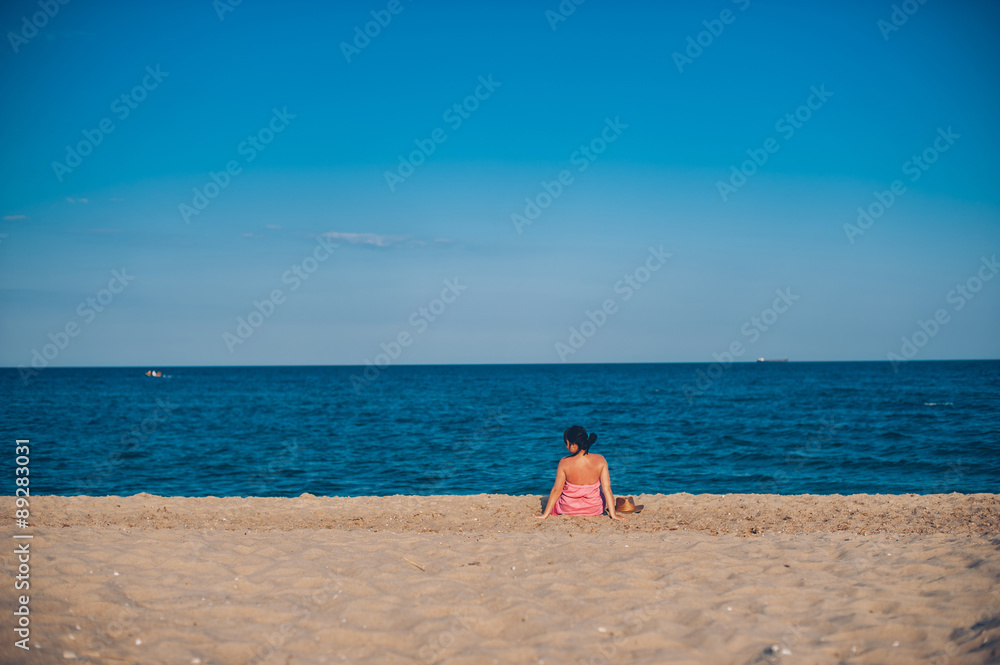 Young woman in summer dress with straw hat looking to a sky and