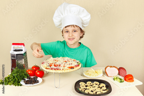 Little funny chef shows how to cook a pizza