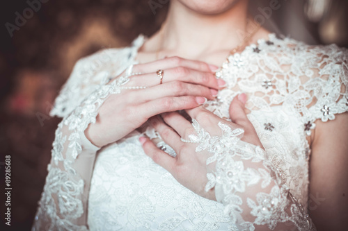 Bride gentle hands on wedding dress photo