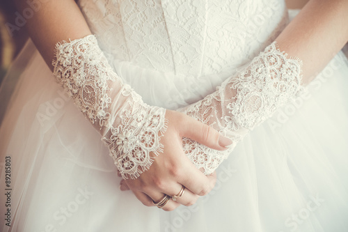 Beautiful bride with hands on white dress photo